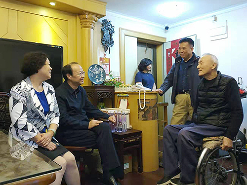 圖為周長奎走訪慰問殘疾人家庭